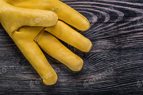 Preview: Leather Yellow Safety Glove On Vintage Wooden Board Construction Concept.