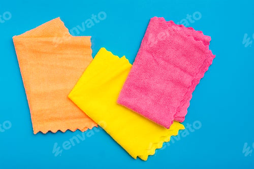 Preview: Multicolored Folded Microfiber Rags On A Blue Background. Cleaning Equipment Concept