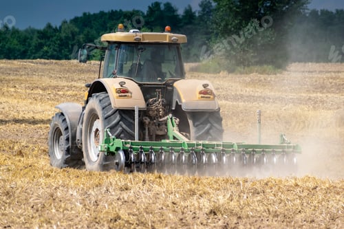 Preview: Yellow Tractor Cultivating The Field After Harvesting Rear View