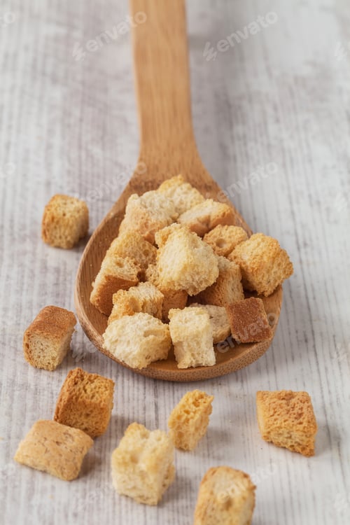 Preview: Tasty Fried Croutons On A Wooden Spoon On The Table