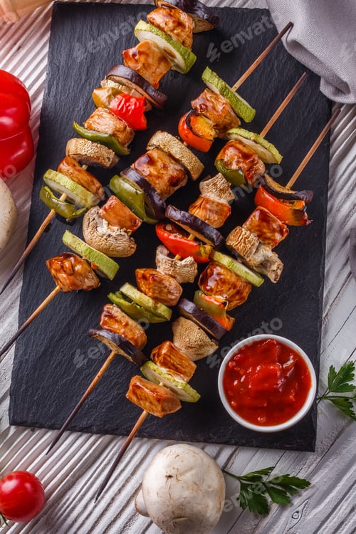 Preview: Chicken Kebabs With Vegetables And Mushrooms On A Rustic Background
