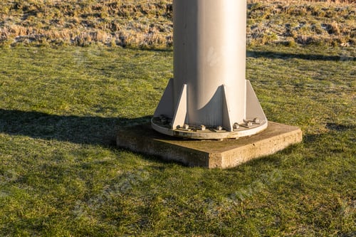 Preview: Base Of A Large Metal Pole Bolted To A Concrete Foundation
