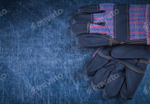 Preview: Pair Of Rubber Protective Gloves On Scratched Metallic Background Construction Concept.