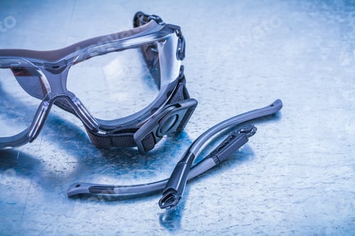 Preview: Plastic Safety Glasses On Metallic Background Construction Concept.