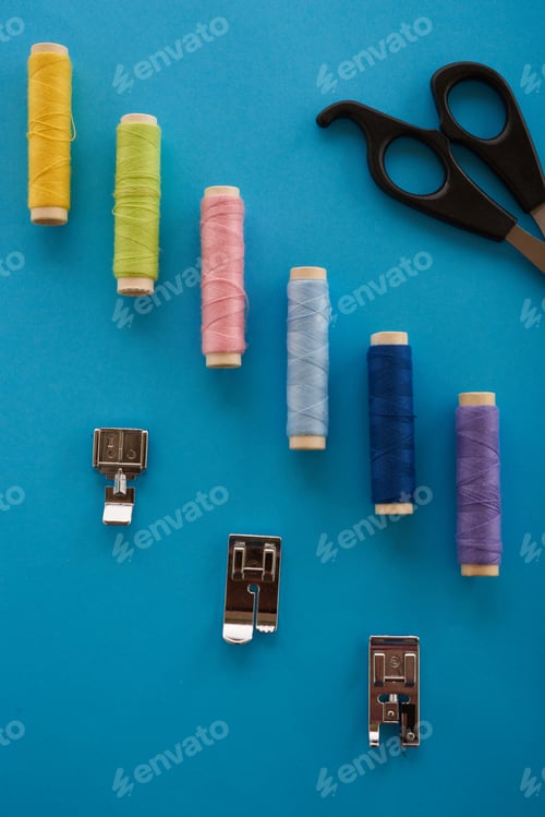 Preview: Color Thread, Scissors And Sewing The Elements On Top Of A Blue Background