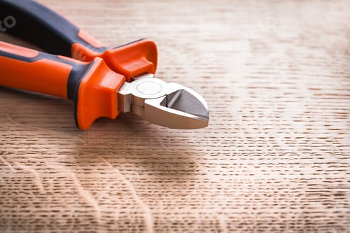 Preview: Nippers Close Up On Wooden Board Construction Concept