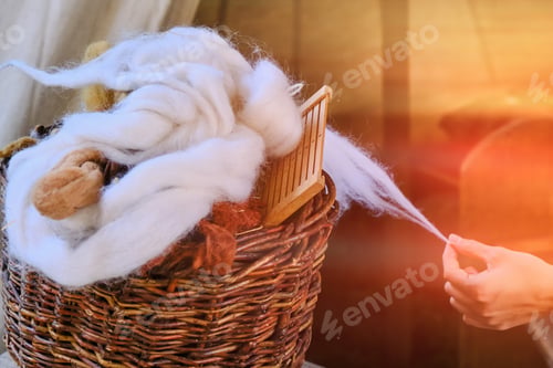 Preview: The Woman Pulls The Yarn From The Wool. The Spinner Creates A Thread Of White Wool.