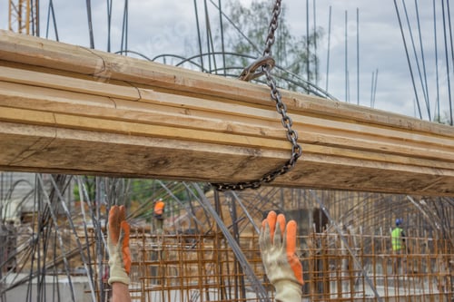Preview: Lifting Timber Plank For Formwork Installation At Construction Site. Selective Focus And Motion