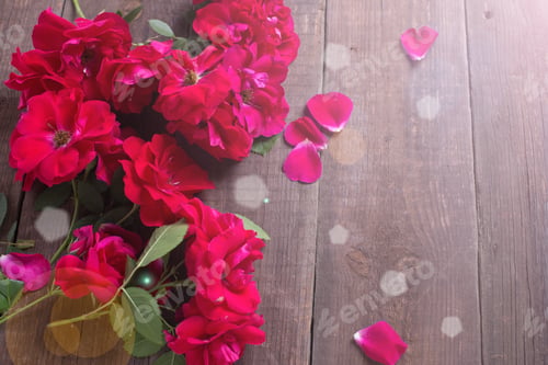Preview: Red Roses In Ray Of Light On Aged Wooden Background. Selective Focus. Place For Text.