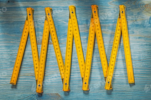 Preview: Yellow Wooden Meter On Vintage Wood Board Directly Above Construction Concept.