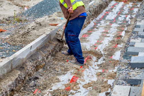 Vista previa: Trabajador rellenando zanjas de cables eléctricos durante un proyecto de reconstrucción de aceras o patios