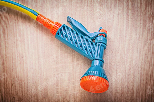 Preview: Garden Rubber Hose With Water Spray Nozzle On Wooden Board Gardening Concept.