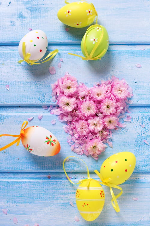 Preview: Easter Postcard. Heart From Pink Sakura Flowers, Bright Easter Eggs On Blue Wooden Background