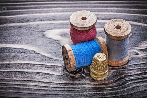 Preview: Vintage Reels Of Thread Thimbles On Wooden Board Handicraft Concept.