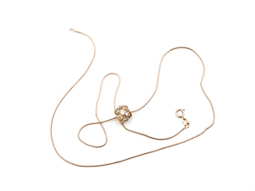 Vista previa: Collar dorado con colgante sobre fondo blanco