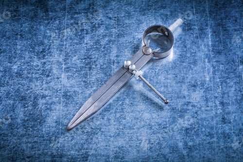 Preview: Pair Of Construction Compasses On Scratched Metallic Background.