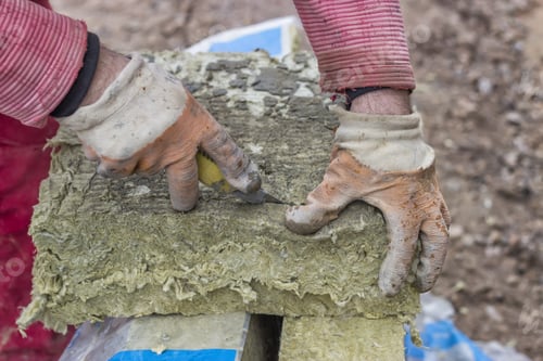 Preview: Cutting Mineral Wool Panel With A Craft Knive At Construction Site. Selective Focus.