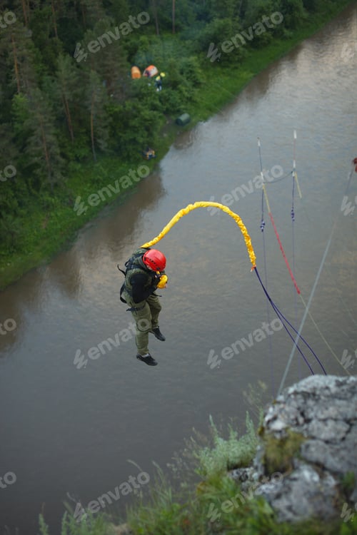 Preview: Athlete Falls Down Against The Background Of A River Tied To A Safety Rope. Ropejumping.