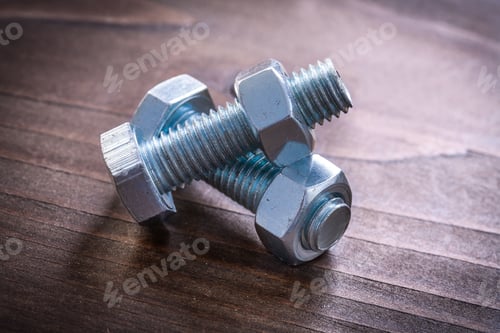 Preview: Vintage Wooden Board With Couple Of Metal Threaded Bolts And Screw Nuts Construction Concept