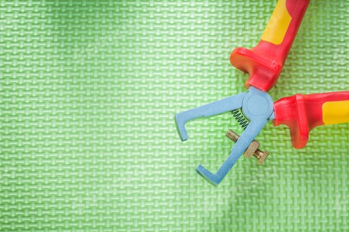 Preview: Insulated Wire Strippers On Green Background Electricity Concept.
