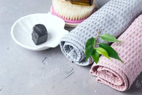 Preview: Flower Oil In Cosmetic Bottles Pink And Gray Towels On Gray Background Cosmetic Or Spa Concept