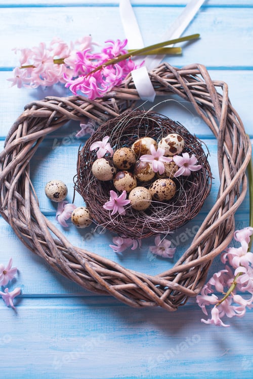 Preview: Decorative Easter Eggs In Nest, Big Heart And Tender Pink Flowers On Blue Wooden Background. Easter