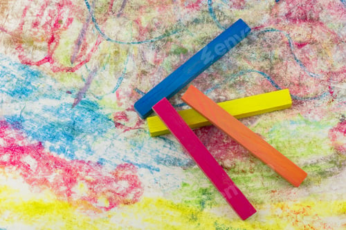 Preview: View Of A Group Of Differently Colored Chalk Lying On Colorful Drawings Of Paper