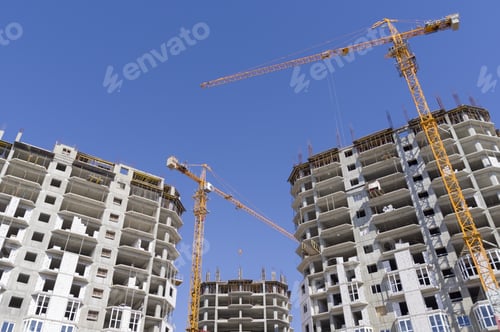 Preview: Building Crane And Building Under Construction Against Evening Blue Sky