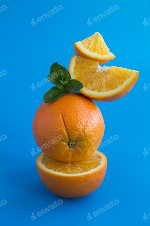 Preview: Oranges Fruit Stacked Pyramid On The Blue Background.Close-Up. Location Vertical.