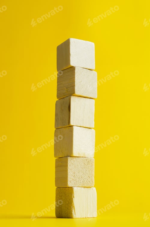 Preview: Stack Of Wooden Cubes Over Bright Yellow Background
