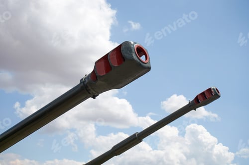 Preview: Closeup Of A Long-Range Military Cannon Defeated Aimed At A Blue Sky With Clouds.