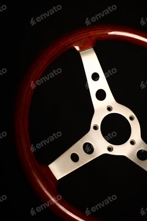 Preview: Detail Of A Wooden Vintage Steering Wheel On Black.