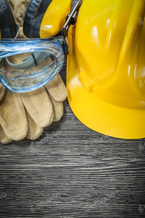 Preview: Protective Gloves Goggles Earmuffs Hard Hat On Wooden Board.