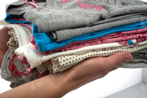 Preview: Folded Stack of Colorful Shirts Held in Hand