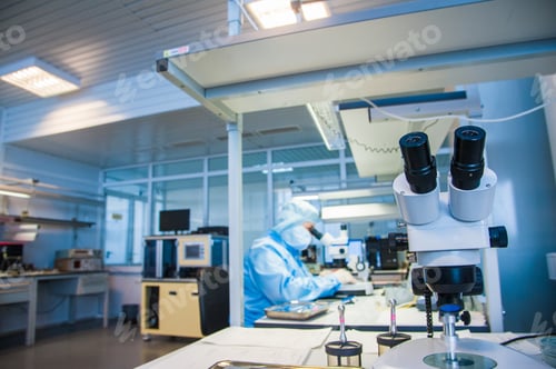 Preview: Lab Technician Working With Microscope in Clean Room