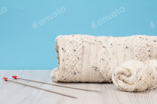 Preview: Wool Skein and Knit Blanket on Wood Surface