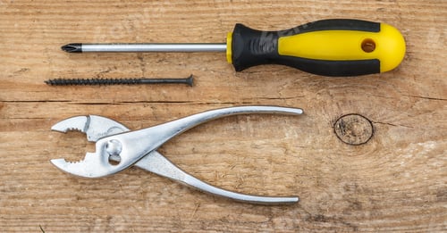 Preview: Working Tools. Screwdriver, Black Screw And Pliers On Wooden Background. Top View.