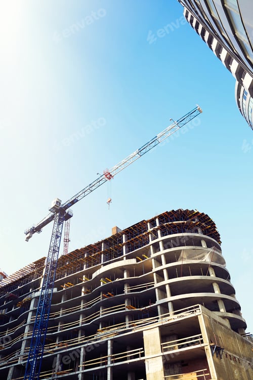 Preview: High Building Under Construction. Side With Cranes Against Blue Sky With Sun Glare.