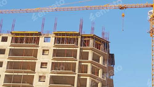 Preview: Building Crane And Building Under Construction Against Evening Blue Sky