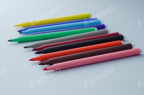 Preview: Multiple Colorful Magic Markers Over Blue Background With Shallow Depth Of Field