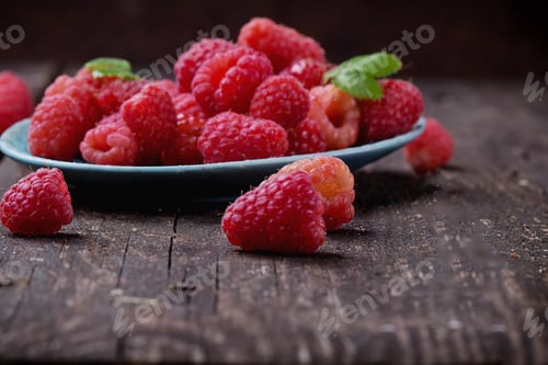 Preview: Fresh Organic Raspberries In Blue Pheasant Plate Over A Rustic Wooden Board