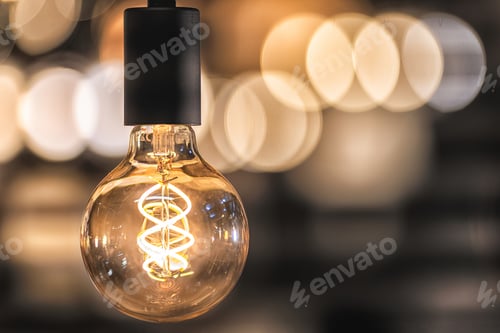 Preview: Glowing Filament Bulb with Warm Bokeh Background
