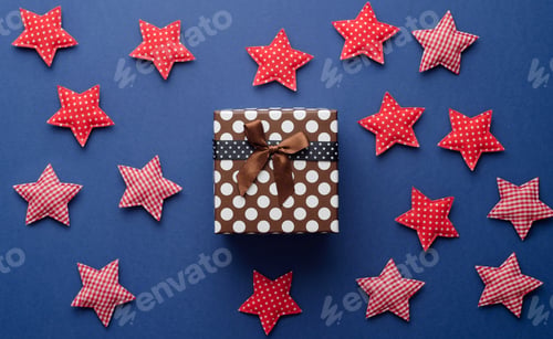 Preview: Christmas Gift Box And Red Stars Over Dark Blue Background, Above View