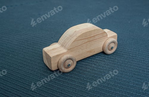 Preview: A Wooden Toy Car On A Blue Mat.