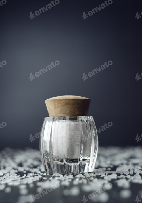Preview: Rustic Salt Shaker Over Black Wooden Table With Salt All Over It