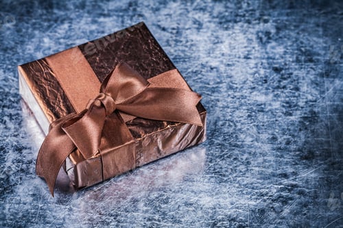 Vista previa: Packed Present With Tied Bow On Metallic Background Holiday Concept.
