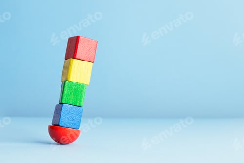 Preview: Colorful Wooden Cubes In Balance Over Blue Background