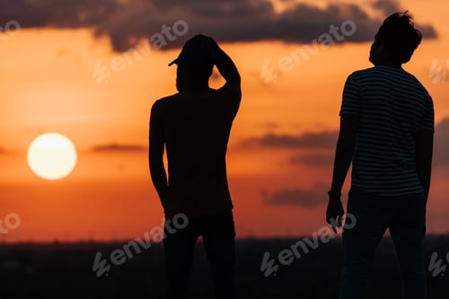 Preview: Silhouette Of Two Indian Male Friends Standing In Front Of The Sun During The Sunset