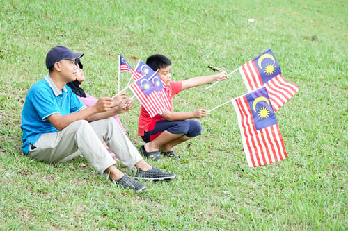 Preview: Independence Day Concept -Asian Sibling Cheerful At Field Holding A Malaysian Flags.
