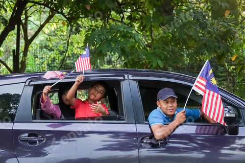 Preview: Independence Day Concept -Asian Sibling Cheerful In A Car Holding A Malaysian Flags.
